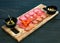Cured meat platter. Chorizo, salami, ham, olives on a wooden board