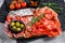 Cured meat platter of traditional Spanish tapas. Chorizo, jamon serrano, lomo and fuet. Gray background. Top view