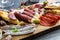 Cured meat platter of traditional Spanish tapas - chorizo, salsichon, jamon serrano, lomo - erved on wooden board with