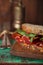 Cured meat sandwich with seeded bread on old wooden table