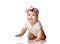 Curios much surprised adorable infant baby girl in white body and hair bow decoration creeps on floor looking at camera