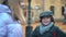 Curios schoolboy smiling talking with schoolgirls standing on college yard on autumn day. Portrait of Caucasian boy