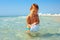 Curious baby boy catches jellyfish in the sea