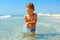 Curious baby boy catches jellyfish in the sea