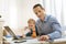 Curious baby touching a laptop while his busy father working