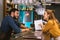 Curious barman looking at the young author and listening to her