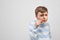 Curious boy looking intently through magnifying glass on white b