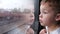 Curious boy looking out of the train window in