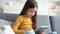 Curious cute preschool kid girl using digital tablet technology device sitting on sofa alone