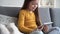 Curious cute preschool kid girl using digital tablet technology device sitting on sofa alone