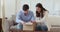 Curious happy young married couple clients unpacking cardboard box.