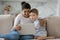 Curious kid and happy nanny holding laptop