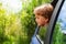 Curious kid looking outside of car window