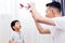 Curious kid looking at the plane toy and playing with father. Asian family playing toys together at home.