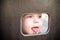 Curious kid spying through the hole in the wooden wall on playground