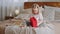 Curious little girl happy preschooler blonde daughter cute baby kid child sitting on cozy bed with festive red gift box