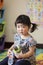 Curious little kid holding colourful plastic glass