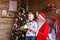 Curious male child receives gift from Santa Claus in decorated f