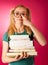 Curious, naughty, playful schoolgirl with stack of books and big