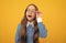 Curious school age girl child look through eyeglasses yellow background, curiosity