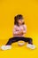 Curious serious little lady sitting on bare floor against bowl