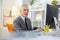 Curious short-haired businessman sitting alone in office