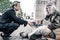 Curious short-haired businessman sitting in front of long-haired homeless