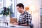 Curious short-haired stylish guy opening box with new product