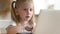 Curious surprised little kid girl using laptop alone at home