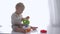 Curious toddler boy played with educational toy tower in bright room