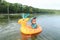 Curious toddler boy sailing inflating ring on sea
