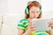 Curious about the world online. a little girl using a digital tablet with headphones at home.