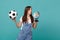 Curious young girl football fan support favorite team with soccer ball, Earth world globe isolated on blue turquoise