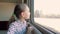 Curious young girl looking at train window