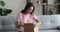 Curious young indian arabic woman opening cardboard box.