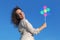 Curl woman holding pinwheel toy and smiling