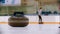 Curling - a granite stone with blue handle on the ice field