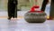 Curling training - a granite stone with red handle on the ice field