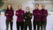 Curling training indoors - the judge standing on the ice rink with her women students - their hands crossed on the chest