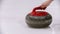 Curling training - woman holding a granite stone with red handle