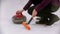 Curling training - woman holding a granite stone with red handle and holding a special brush