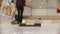 Curling training - a woman pushes the granite stone using a brush - skating to the stand