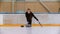 Curling training - a young woman with long hair on the ice rink holding a granite stone and holding a brush