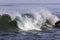 Curling wave, Pacific Ocean near Malibu, California. Rock nearby.