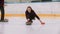 Curling - a young woman in glasses pushes off in the ice field with a granite stone