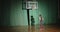 Curly basketball player looks at the basket holds the ball prepares confidence alone shadow bright ray play