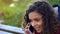 Curly biracial woman actively talking over smartphone, conversation with friend