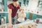 Curly blonde-haired boy having fun holding little baking tins