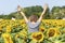 Curly blonde woman, back turned, unrecognizable, emerging from a field of sunflowers