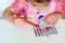 Curly brunette cute little toddler girl painting with color pen paper menorah and candle.